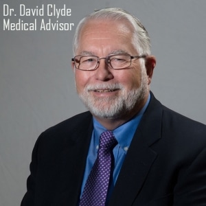 Dr. David Clyde Dressed in Suit with a Blue Shirt and Purple Tie with Gray Dots