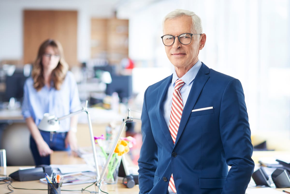 Businessman with blue suit, light blue shirt and red striped tie.