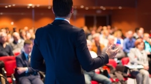 Business executive speaking in front of people in a room