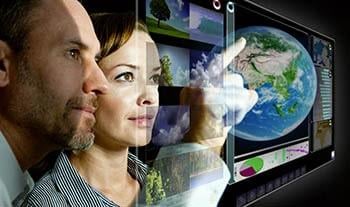 Woman and man looking at transparent screen with a globe on it