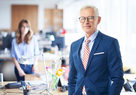 Businessman with blue suit, light blue shirt and red striped tie.