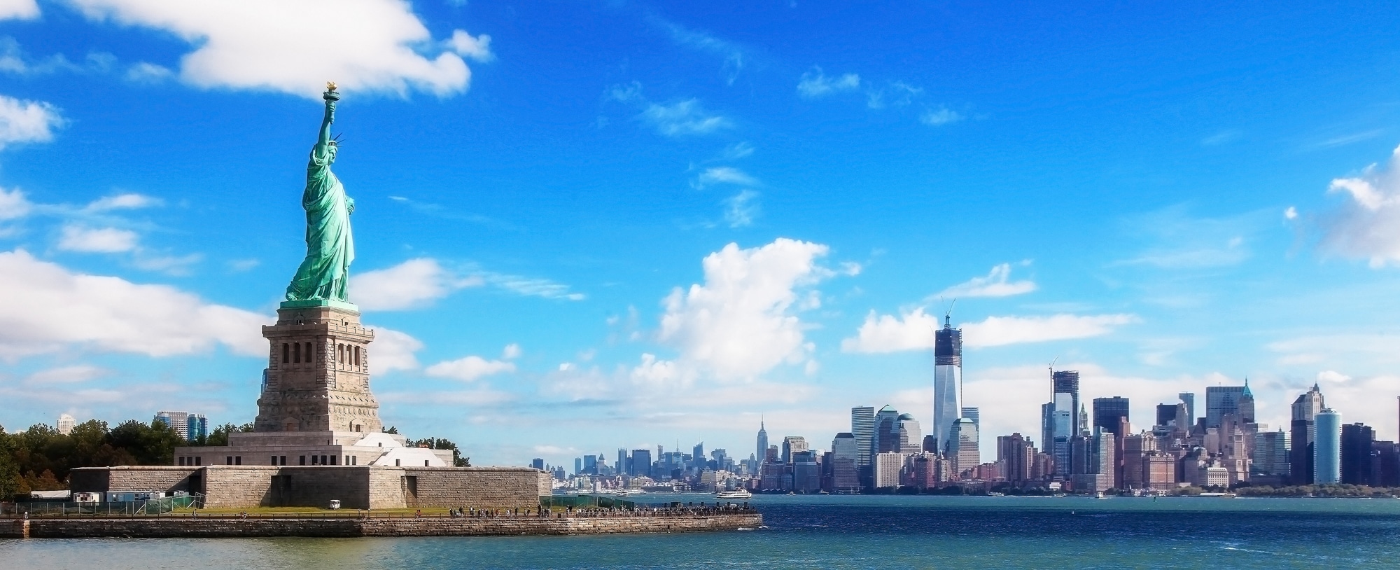 Statue of Liberty and NYC skyline on sunny day